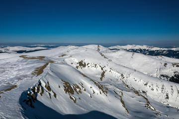 Landscape with mountain range covered in snow at sunset