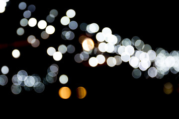 Abstract bokeh of white city lights on black background. defocused and blurred many round light