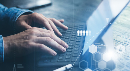 Businessman using tablet device and electronic pen stylus while working at office.Closeup view of male hands pointing tablet screen and typing keyboard