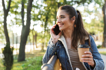 Poster - Smiling young woman wearing jacket and sunglasses