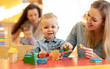 © Oksana Kuzmina - Kindergarten teacher playing with toddler in nursery. Developmental toys for preschool.
