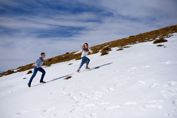 People having fun and running in mountains on the background of high snow-capped peaks