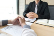 © Puwasit Inyavileart - Young men are being interviewed by employers. The employer wears a black suit explaining the job application of the young man.