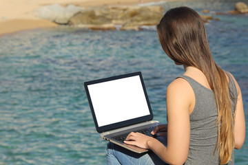 Poster - Woman using laptop showing blank screen on the beach