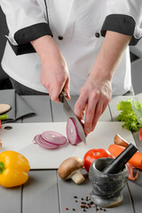 Wall Mural - Chef cutting a red onion