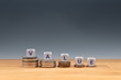 © Fokussiert - Symbol for decreasing value. Dice placed on stacks of coins form the word 'value'.
