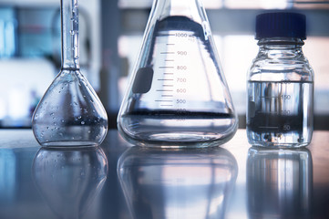 clear flask and water in the bottle in medical science laboratory background