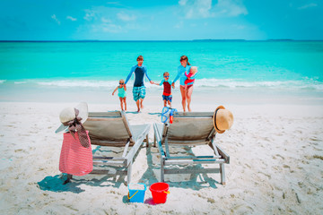 Wall Mural - mom, dad with kids have fun on beach vacation, family at sea