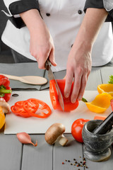 Wall Mural - Chef cook slicing a pepper