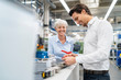 © Westend61 - Happy businessman and senior businesswoman examining workpiece in a factory
