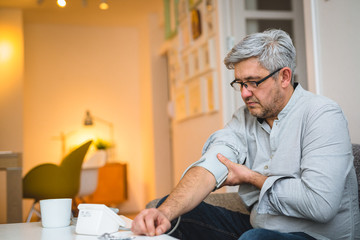 man measuring blood pressure in his home