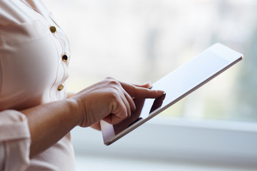 Wall Mural - woman working on a digital tablet near a window