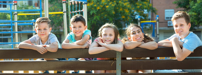 Wall Mural - Five children sitting on bench