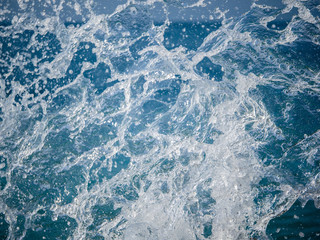 Splashes of water against the sea on a sunny summer day