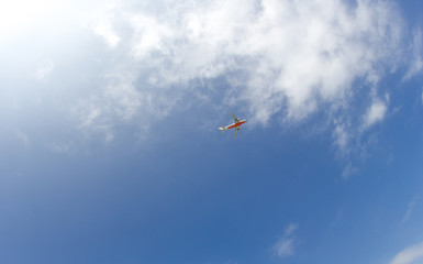 Passenger plane flying in the blue sunny sky