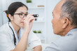 © paulaphoto - Asian doctor woman examine eyes of senior old man in the clinic.  Senior looks in instrument for checking eyes at ophthalmologist. Health care and medical concept.