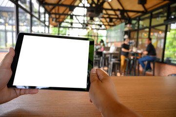 Poster - businessman hand working on tablet on wooden desk tablet with blank screen mockup Digital tablet computer