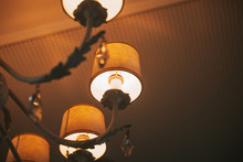 Upward View Of A Chandelier With Yellow Bulbs. Ceilling Lamp. Warm Atmosphere. Interior Object.