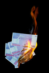 five hundred euro fakes are burning on a black background