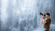 © zephyr_p - Asian man traveler and photographer using digital camera taking photo at waterfall. Travel lifestyle or nature photography concepts