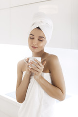 Wall Mural - Young woman in towel enjoying coffee at home.