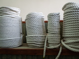 Fototapeta Maki - A large number of the twisted ropes in a roll. Ropes on a counter of shop. Sale of various ropes