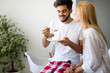 © NDABCREATIVITY - Cute young cheerful couple spending time at home