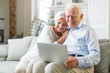 © pikselstock - Senior couple using laptop computer at home