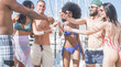 Happy friends drinking champagne in summer boat party - Young trendy people having fun drinking and laughing together - Youth lifestyle and vacation concept - Focus on hands glasses