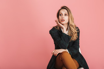 Canvas Print - Photo of successful businesswoman smiling and sitting in chair isolated over pink background