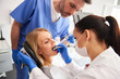 © gpointstudio - Young woman is getting treatment in dentist's office
