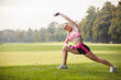 © Olga Mishyna - sport girl making exercises outdoors. Young sport woman in a park. Sport and fitness on open air. Exercise lunge leg on the grass and stretching