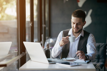 Wall Mural - Young man drawing template for the web site associated with digital marketing, current trends and tendencies of UX / UI design. Businessman who rules his company remotely, like a freelancer