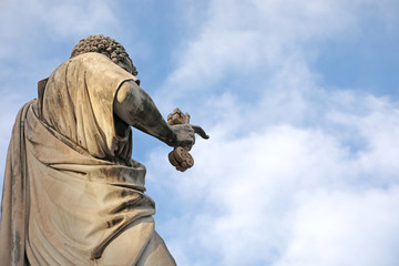 Ancient statue of Saint Peter in key on the hand and blue sky