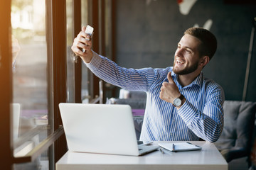 Wall Mural - Young man drawing template for the web site associated with digital marketing, current trends and tendencies of UX / UI design. Businessman who rules his company remotely, like a freelancer