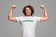 © kegfire - Strong volunteer smiling and flexing muscles