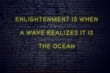 Positive inspiring quote on neon sign against brick wall enlightenment is when a wave realizes it is the ocean