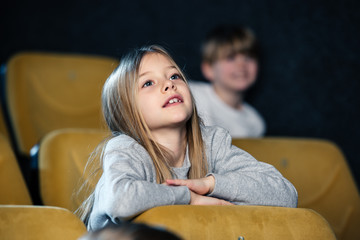 selective focus of cute attentive child watching movie in cinema