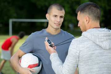 portrait of young sportsman with coach outdoors