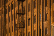 © nuclear_xonix - Facade of the old mill building at nighttime. Building of red brick. Fire escape on the facade