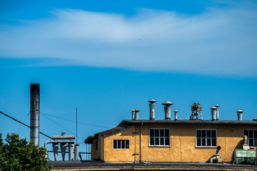 Top of obsolete vintage industrial building and facilities on blue sky background