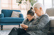© MaaHoo Studio/Stocksy - Senior grandmother using smartphone with her granddaughter