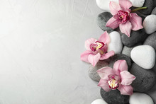 Zen Stones And Exotic Flowers On Grey Background, Top View With Space For Text