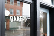 © Melissa Ross/Stocksy - A store front window displaying the word Bakery.