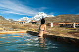 Fototapeta Natura - Young Girl in Hot Springs overlooking snowy mountian in Peru
