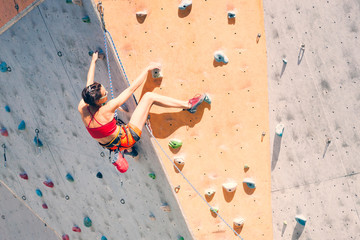 Poster - A girl climbs a climbing wall.