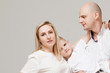 © Ulia Koltyrina - Mom dad and son, young family portrait on light grey background.