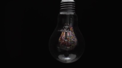 Fototapete - Lightbulb filled with colored ball black background. Macro view.