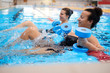 © Nejron Photo - Multiracial couple attending water aerobics class in a swimming pool