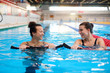 © Nejron Photo - Multiracial couple attending water aerobics class in a swimming pool